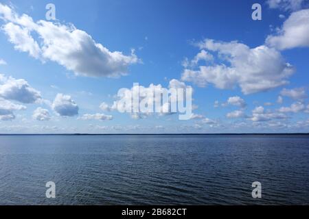 Schöne weißrussische Skyscape am großen See im Nationalpark mit glitzerndem Wasser und wundervollen Wolken im blauen Himmel Landschaftshintergrund Stockfoto