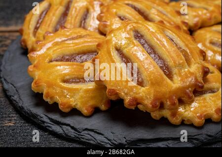 Kleine runde, frisch gebackene Plätzchen mit Äpfeln, die dicht beieinander liegen Stockfoto