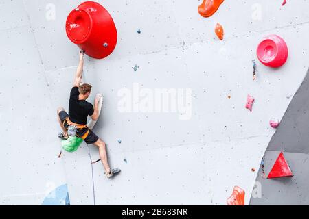 Sport- und Fitness-Mann im Extreme Climbing Wall Boulder Gym Stockfoto