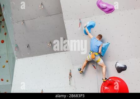 Sport- und Fitness-Mann im Extreme Climbing Wall Boulder Gym Stockfoto