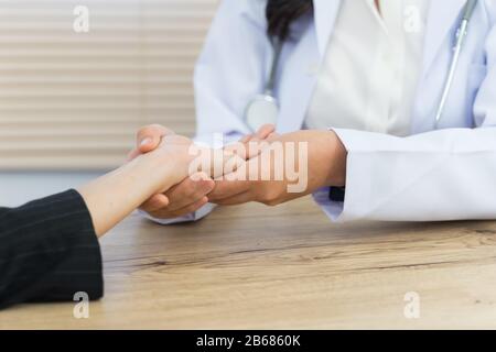 Nahaufnahme eines Arztes, der die Hände des Patienten hält, der grundlegende medizinische Untersuchungen und Diagnosen durchgeführt hat. Ein Arzt untersucht den Patienten im Krankenhaus. Stockfoto