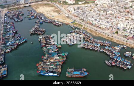 Sanya. März 2020. Das Luftbild vom 10. März 2020 zeigt Fischerboote, die am zentralen Fischereihafen Yazhou in Sanya, der südchinesischen Provinz Hainan, anlegen. Mehr als 400 Fischerboote im Hafen haben begonnen zu arbeiten, als die Fischereiindustrie der Provinz den Betrieb wieder aufgenommen hat. Credit: Guo Cheng/Xinhua/Alamy Live News Stockfoto