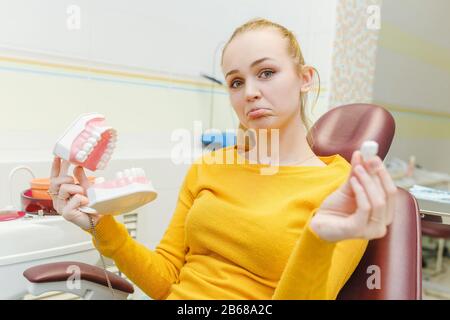 Junge Frau mit Zahnkiefermodell in der Klinik für Stomatologie Stockfoto