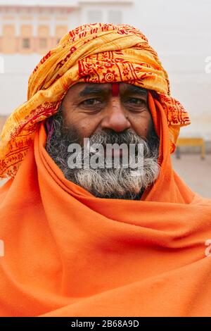 Varanasi, INDIEN - 3. JANUAR 2020: Unidentifizierter heiliger Hindu-Sadhu-Mann, sitzt auf dem Ghat nahe dem Fluss Ganges in Varanasi, Indien. Der Tourismus hat sich auf einer Höhe von entwickelt Stockfoto