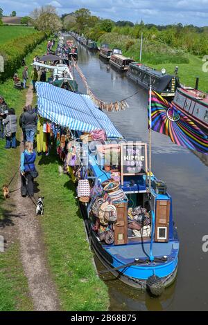 Blick von einer Brücke hinunter auf eine Reihe von Schmalboot-Händlern, die an einem sonnigen Sommernachmittag in der Nähe von Norbury in Staffordshire UK moored. Stockfoto