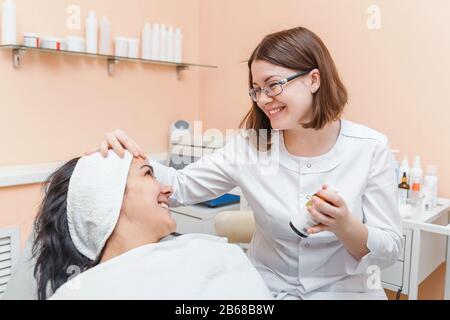Ein weiblicher Arzt zeigt eine medizinische Vorbereitung auf einen Patienten in einer Klinik für ästhetische Medizin und Kosmetologie Stockfoto