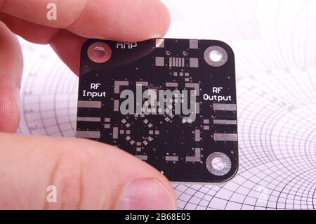 Nicht montierte Hochfrequenz-Leiterplatte in der Elektronikkonstruktion und in den Händen des Prüfingenieurs Stockfoto