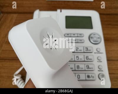 Festnetztelefon am Holz-Büroschreibtisch. Kommunikationstechnik-Konzept Stockfoto
