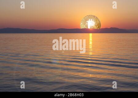 Bitcoin-Symbol als Sonne bei Sonnenaufgang, die über ruhigem Meer steigt Stockfoto