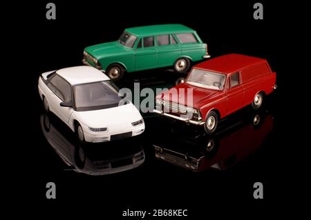 Sammlung von 3 sowjetischen Modellautos mit Druckguss auf schwarzem reflektierendem Hintergrund Stockfoto