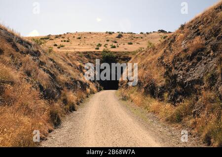 Einer von mehreren Tunneln entlang des Central Otago Rail Trail, der die Eisenbahn durch die Poolburn Gorge zum und vom Manuherikia River führte. Stockfoto