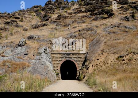 Einer von mehreren Tunneln entlang des Central Otago Rail Trail, der die Eisenbahn durch die Poolburn Gorge zum und vom Manuherikia River führte. Stockfoto