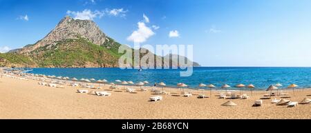 Strand mit Sonnenschirmen und liegen am Ufer des Mittelmeers in der Türkei Stockfoto