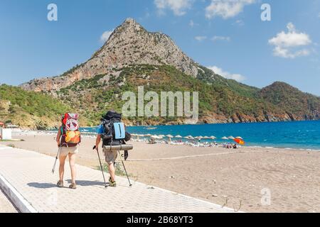 Eine Gruppe von Wanderern mit Rucksäcken, die auf dem Lykischen Weg in der Nähe des Strandes in der Adrasanbucht in der Türkei spazieren gehen Stockfoto