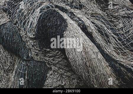 Haufen kommerzieller Fischernetze und Kiemennetze an einem Fischerkai. Stockfoto