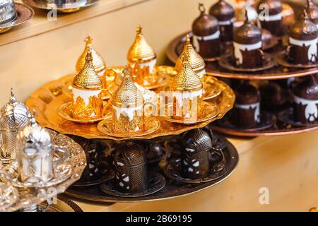 Tee- und Kaffeeset mit traditionellen goldenen Tassen auf dem orientalischen Markt Basar. Stockfoto