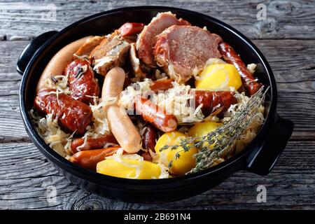 Gericht im Elsaß: Sauerkohl mit Fleisch: Schweineloin und Speck und Würstchen und Kartoffel in Weißweinthyme, Wacholderbeeren, Knoblauch auf a serviert Stockfoto