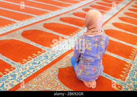 Moslemfrau trägt modischen Schal und betet in der Moschee Stockfoto