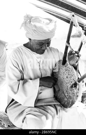 Assuan, Ägypten - 6. Februar 2020 Alter Mann, der auf einem Smemsemya Musikinstrument spielt Stockfoto