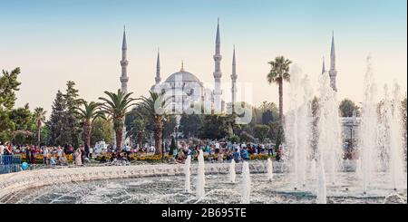 Istanbul, TÜRKEI - 10. SEPTEMBER 2017: Die blaue Moschee Sultan Ahmet mit Brunnen und Menschen, die im Park ruhen Stockfoto