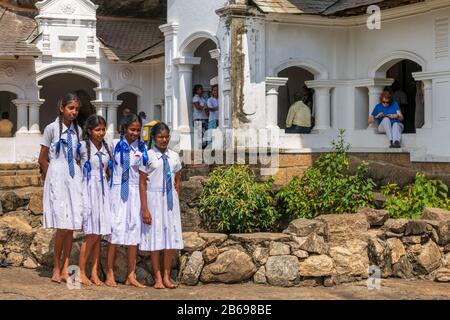 Eine Schule Partei posieren für ein Foto ausserhalb der Eindrucksvollsten von Sri Lanka's Cave Tempel, reich verzierte fünf Heiligtümern von 'Dambulla Rock und Stockfoto