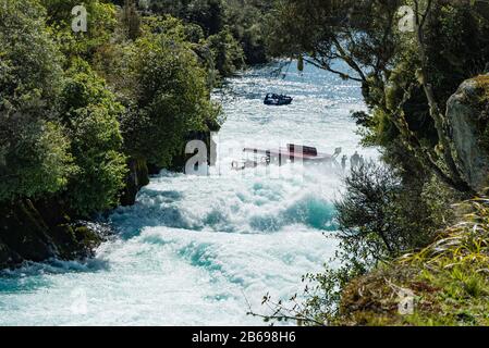 Die Huka Falls River Cruise zieht ein, um einen Blick auf die Hauptkaskade zu werfen, während eine Bootstour anblickt. Stockfoto