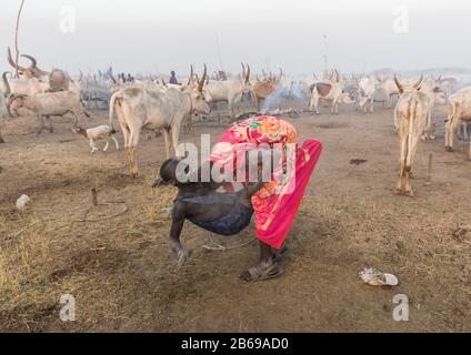 Mundari Stammjungen, die in einem Viehlager, Central Equatoria, Terekeka, Südsudan, wringen Stockfoto