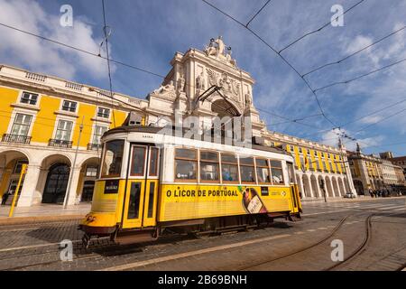 Lissabon, Portugal - 2. März 2020: Berühmte gelbe Straßenbahn 28 am Praca do Comercio vor Arco da Rua Augusta Stockfoto