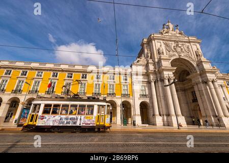 Lissabon, Portugal - 2. März 2020: Berühmte gelbe Straßenbahn 28 am Praca do Comercio vor Arco da Rua Augusta Stockfoto