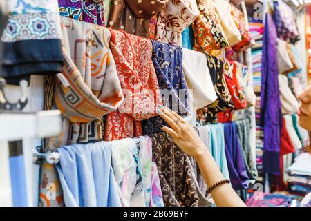 Junge Frau Einkaufen Für EINEN neuen Schal und buntes Material in Basar wählen Stockfoto