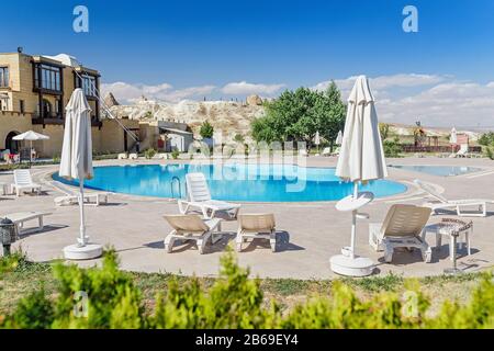 23. SEPTEMBER 2017, GÖREME, TÜRKEI: Schöner Swimmingpool und Liegestühle im Luxushotel in Kappadokien Stockfoto