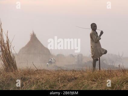 Mundari Stamm Junge inmitten langer Hörner Kühe in einem Viehlager, Central Equatoria, Terekeka, Südsudan Stockfoto