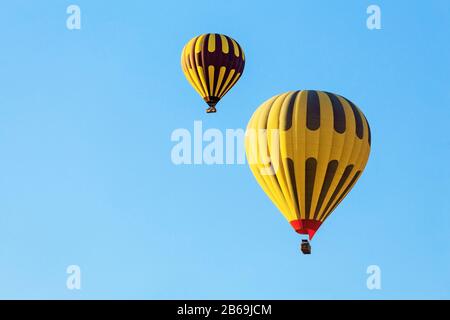 Viele unerkennbare bunte Heißluftballons gegen blauen Himmel Stockfoto