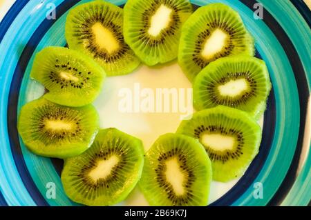 Scheiben eines Kiwis auf einem bunten Teller Stockfoto