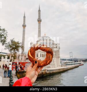 Türkische simit mit Ortakoy-Moschee im Hintergrund Stockfoto