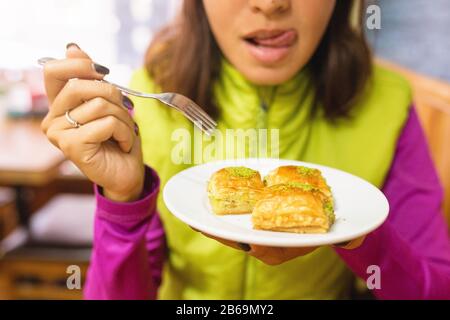 Frau isst türkisches Baklava-Dessert im Café Stockfoto