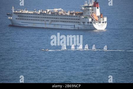 Kleine Segelboote, die vor einem großen Schiff in Las Palmas, Gran Canaria, einer der Kanarischen Inseln von Spains vor dem Nordwesten Afrikas, geschleppt werden Stockfoto