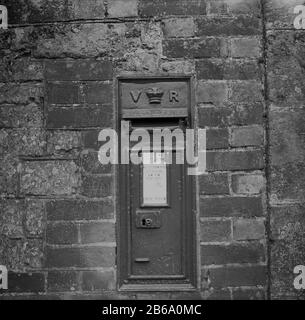 1950er Jahre, historisch, ein viktorianischer Briefkasten aus Royal Mail, der in die Ziegelwand integriert ist, Stopham House, Pulborough, West Sussex, England, Großbritannien, kürzlich gemalt. Dieser alte Briefkasten mit den Initialen VR auf wurde zwischen 1853-1901 in der Regierungszeit der britischen Königin Victoria konstruiert. Postfächer wurden erstmals in Großbritannien im Jahr 1853 eingeführt. Stockfoto