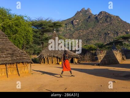 Frau, die in einem traditionellen Dorf des Larim-Stammes, Boya Mountains, Imatong, Südsudan, vorbeigeht Stockfoto