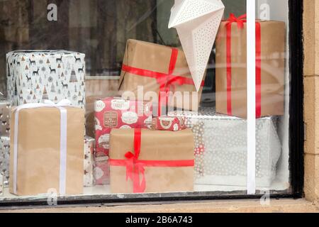 Geschenke in einem Fenster. Schachteln unterschiedlicher Größe mit Schleifen. Schmutzige Schaufenster Stockfoto