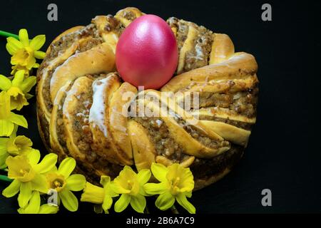 Traditionelle europäische Ostern Kranz Osterkranz Bäckerei mit Walnüssen einen Kranz mit einem Osterei in der Mitte und Narzissen Narzissen Stockfoto