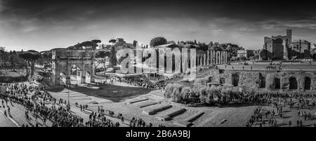 Ein schwarz-weißes Panorama mit Blick auf die Piazza del Colosseo und die Menschenmassen an einem Wintermorgen, aufgenommen vom Kolosseum. Stockfoto