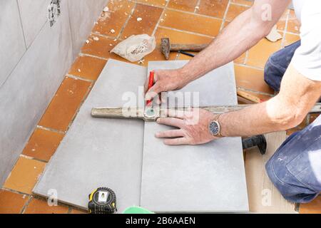 Der fliesenleger Maßnahmen die Fliesen vor dem Schneiden Stockfoto