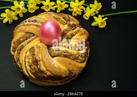 Traditionelle europäische Ostern Kranz Osterkranz Bäckerei mit Walnüssen einen Kranz mit einem Osterei in der Mitte und Narzissen Narzissen Stockfoto