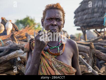 Die Frau des hohen Toposa-Stammes raucht in einem Dorf, Namorunyang State, Kapoeta, Südsudan Stockfoto