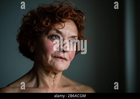 Frau am Fenster, die über das Leben nachdenkt Stockfoto