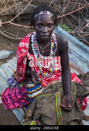 Porträt einer Toposa-Stammfrau, die einen Rock näht, Namorunyang State, Kapoeta, Südsudan Stockfoto