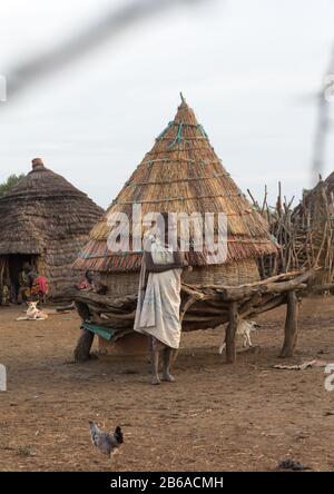 Porträt einer Toposa-Stammfrau vor einem Getreidespeicher, Namorunyang State, Kapoeta, Südsudan Stockfoto