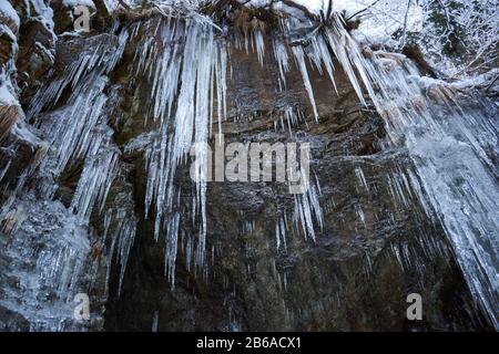 Kristallklare scharfe Eiszapfen hängen auf dem Berg Stockfoto