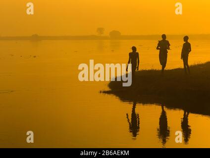 Menschen aus dem Stamm der Mundari am Ufer des Nils bei Sonnenuntergang, Central Equatoria, Terekeka, Südsudan Stockfoto